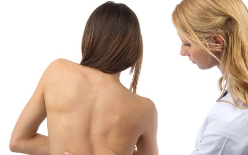 The woman is consulting with a doctor about her spinal curvature