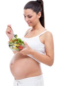 pregnant woman eating vegetable salad,