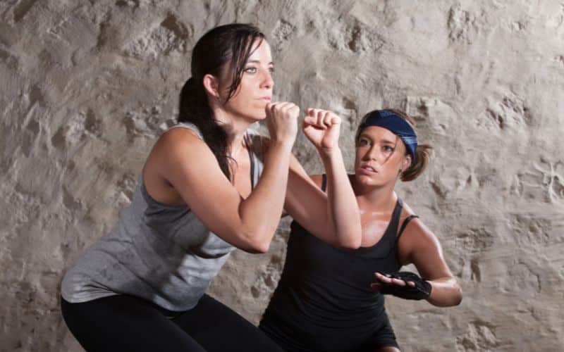 Lady and Trainer Sweating During Exercise