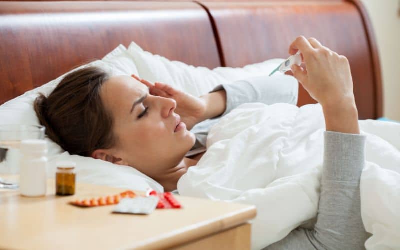  woman with a fever lying in bed