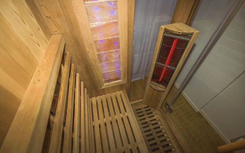 Infrared sauna interior close up view. Wooden walls and bench, ceramic heaters.
